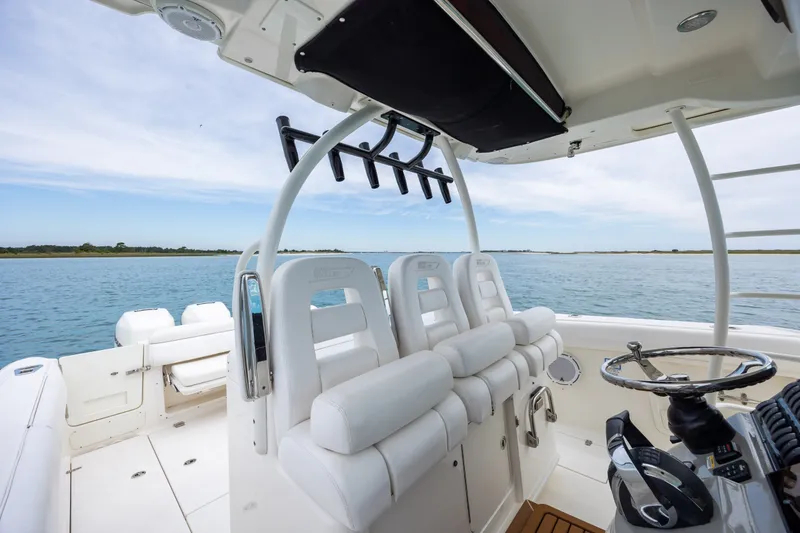 Slide: The Image of 2017 Boston Whaler 370 Outrage boat interior with helm and seating, on calm water. - 31