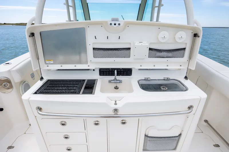 Slide: The Image of 2017 Boston Whaler 370 Outrage boat kitchen with grill, sink, and storage compartments. - 25
