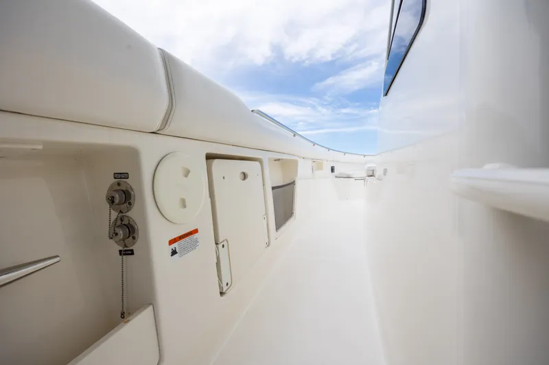Slide: The Image of 2017 Boston Whaler 370 Outrage deck view with storage compartments and clear sky. - 35