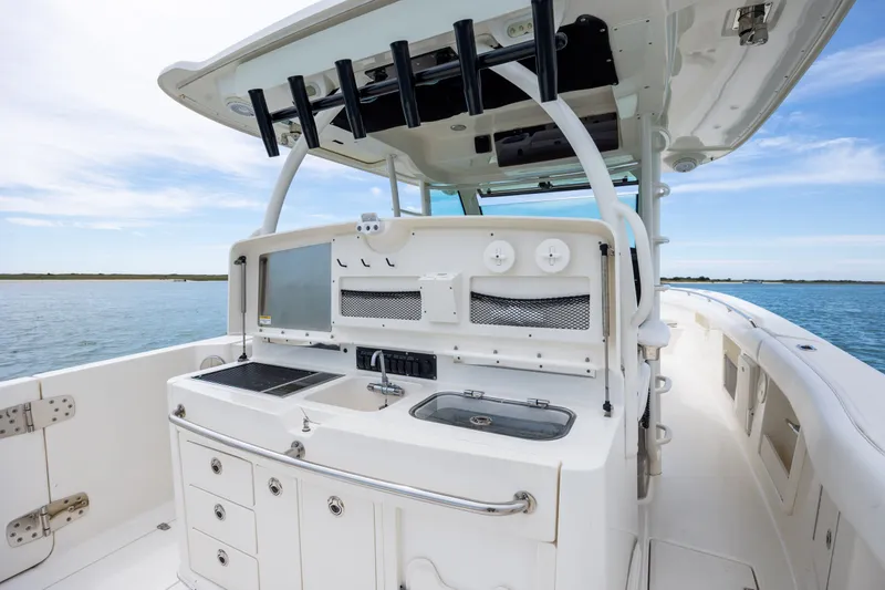 Slide: The Image of 2017 Boston Whaler 370 Outrage boat interior with fishing rod holders and storage compartments. - 24