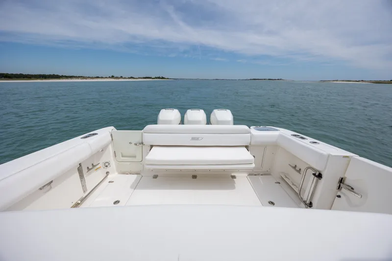 Slide: The Image of 2017 Boston Whaler 370 Outrage boat on open water, showcasing spacious deck and seating. - 17