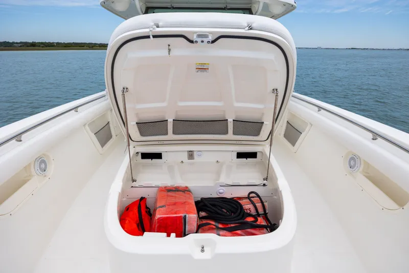 Slide: The Image of Open storage compartment on 2017 Boston Whaler 370 Outrage boat, containing safety equipment. - 42