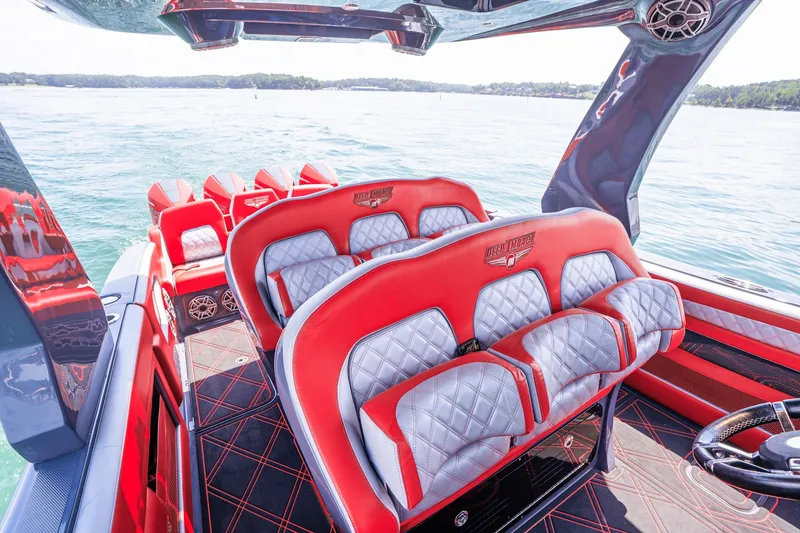 Slide: The Image of Luxurious 2022 Deep Impact 399 Sport boat interior with red and gray seating on the water. - 59