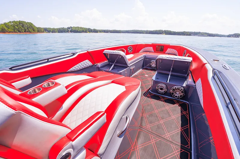 Slide: The Image of Luxurious 2022 Deep Impact 399 Sport boat interior with red and white seating on a serene lake. - 30