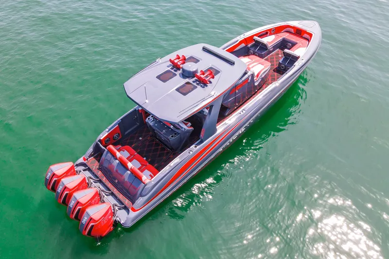 Slide: The Image of 2022 Deep Impact 399 Sport boat with red accents on clear water. - 20