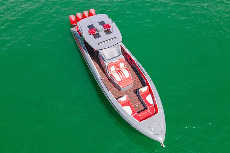 Slide: The Image of 2022 Deep Impact 399 Sport boat with red and white seating on vibrant green water. - 25