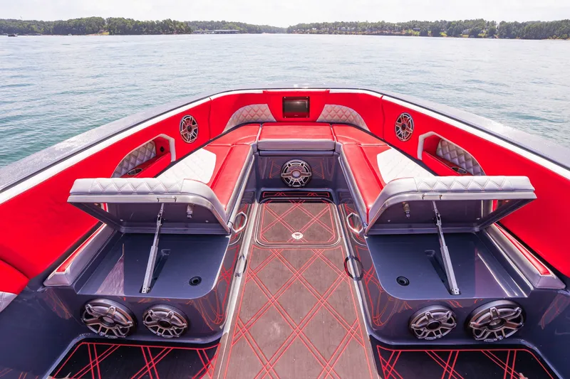 Slide: The Image of 2022 Deep Impact 399 Sport boat interior with red and white seating, open storage, and speakers. - 33