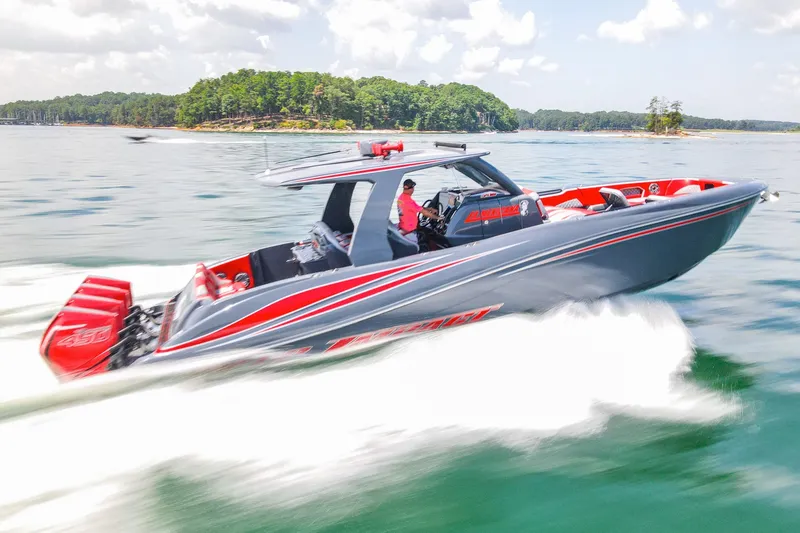 Slide: The Image of 2022 Deep Impact 399 Sport boat speeding on a lake with lush green island backdrop. - 95
