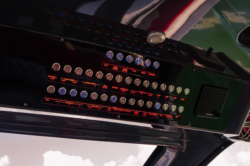 Slide: The Image of Control panel of a 2022 Deep Impact 399 Sport boat with labeled switches and buttons. - 53