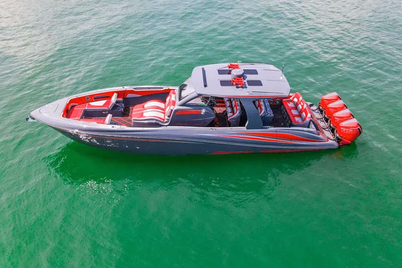 Slide: The Image of 2022 Deep Impact 399 Sport boat on clear green water, featuring sleek design and vibrant red accents. - 19