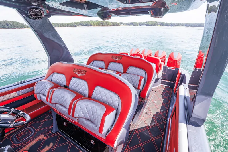 Slide: The Image of Interior of 2022 Deep Impact 399 Sport boat with red and gray seating on water. - 60