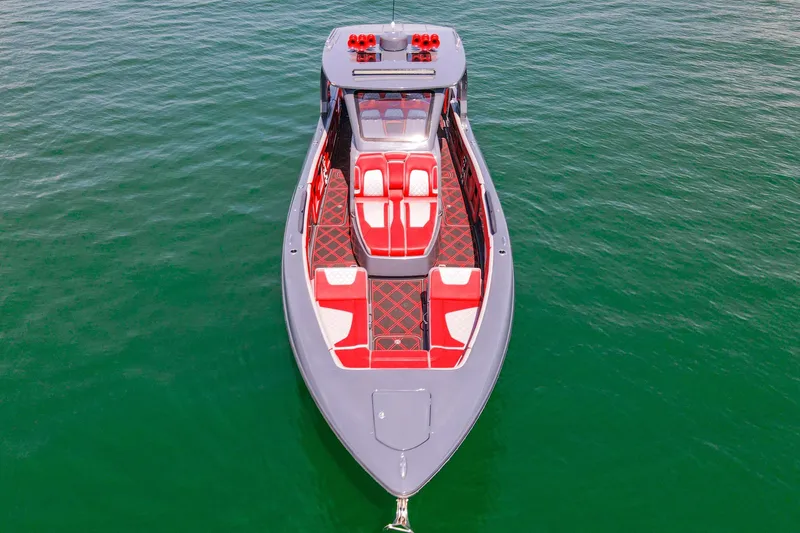 Slide: The Image of 2022 Deep Impact 399 Sport boat with red and white seating on calm water. - 27