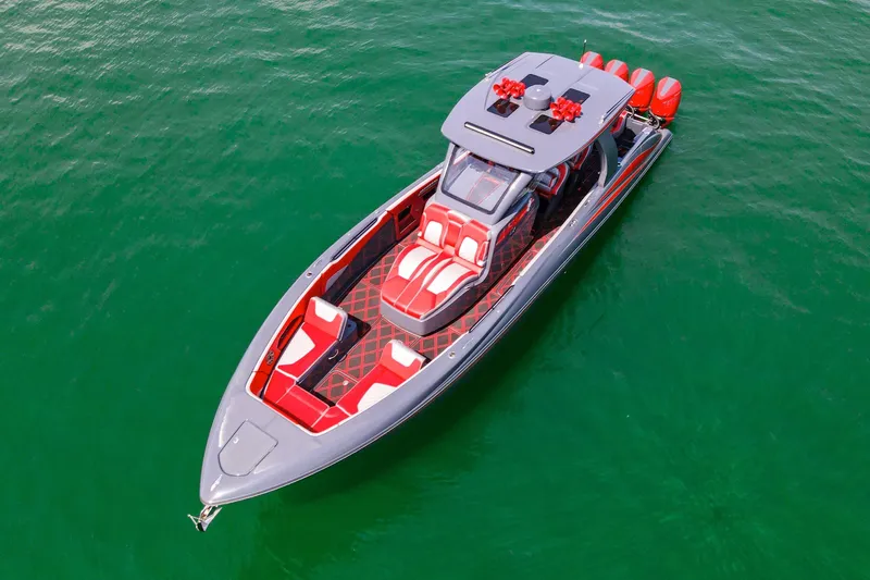 Slide: The Image of 2022 Deep Impact 399 Sport boat with red and gray design on green water. - 21
