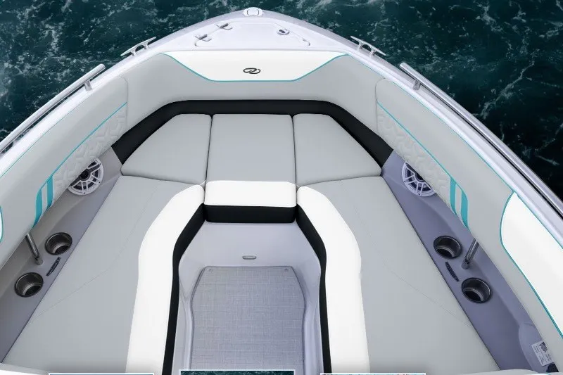 Slide: The Image of 2027 Regal LS4 Surf boat interior with cushioned seating and cup holders on the water. - 2
