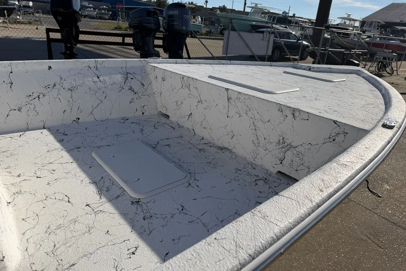 Slide: The Image of 2026 Skuta 21 Tournament V boat deck with marble-like pattern, docked near outboard motors. - 34