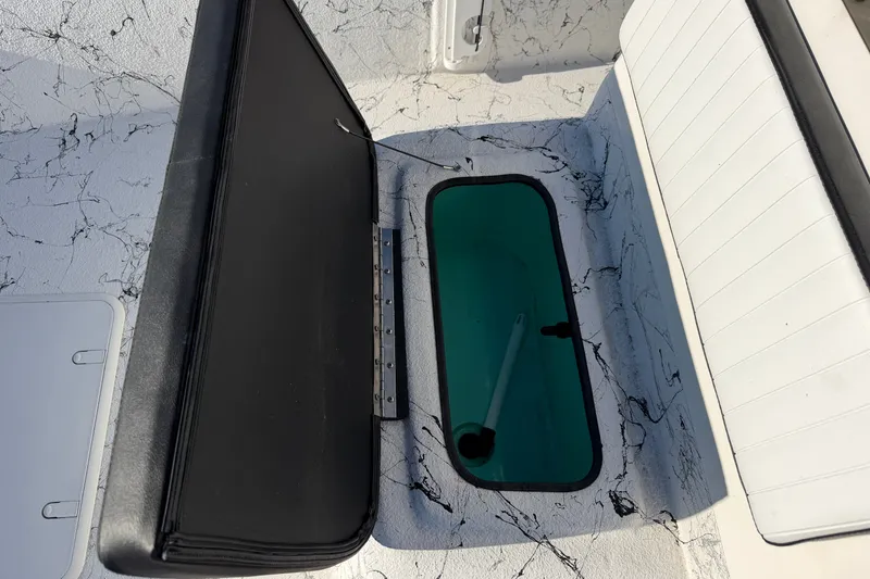 Slide: The Image of Open storage compartment on 2026 Skuta 21 Tournament V boat with black and white seating. - 46