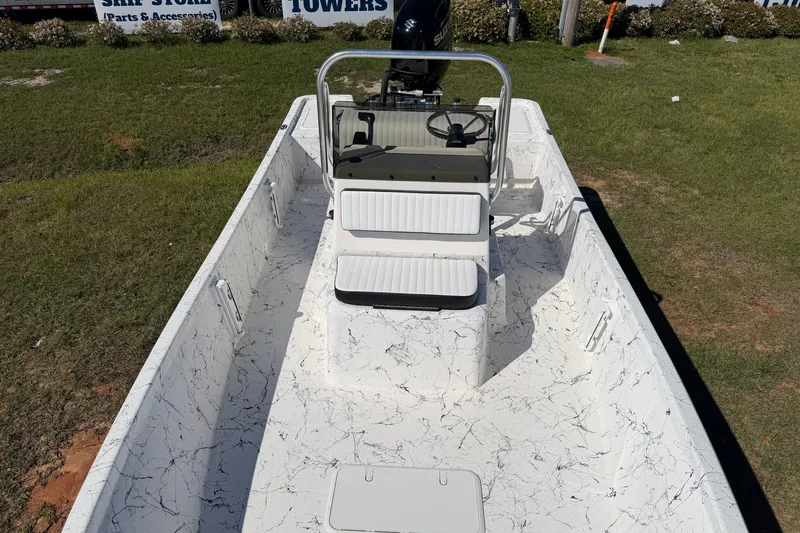Slide: The Image of 2026 Skuta 21 Tournament V boat with white interior and steering console on grass. - 15