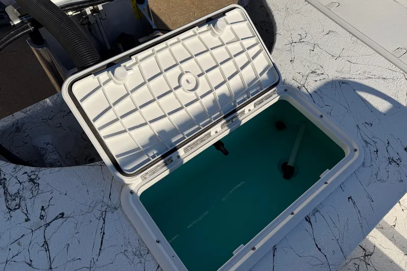 Slide: The Image of Open storage compartment on 2026 Skuta 21 Tournament V boat, featuring a white lid and blue interior. - 47