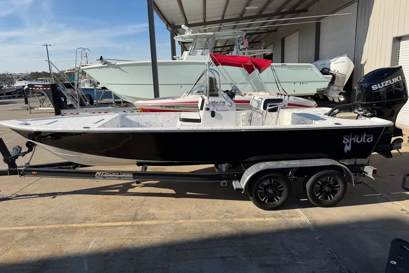 The Image of 2026 Skuta 21 Tournament V boat on trailer, featuring Suzuki outboard motor. - 0