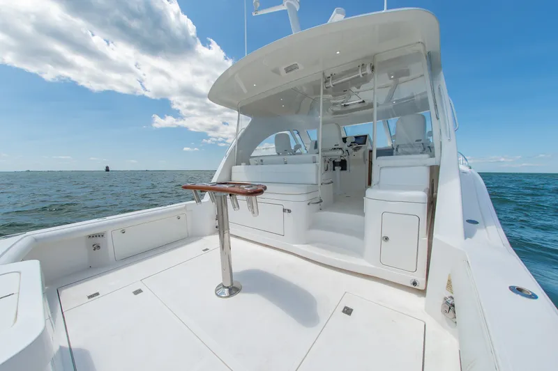 Slide: The Image of 2013 Cabo 40 Hardtop Express yacht on open water, featuring spacious deck and helm. - 20
