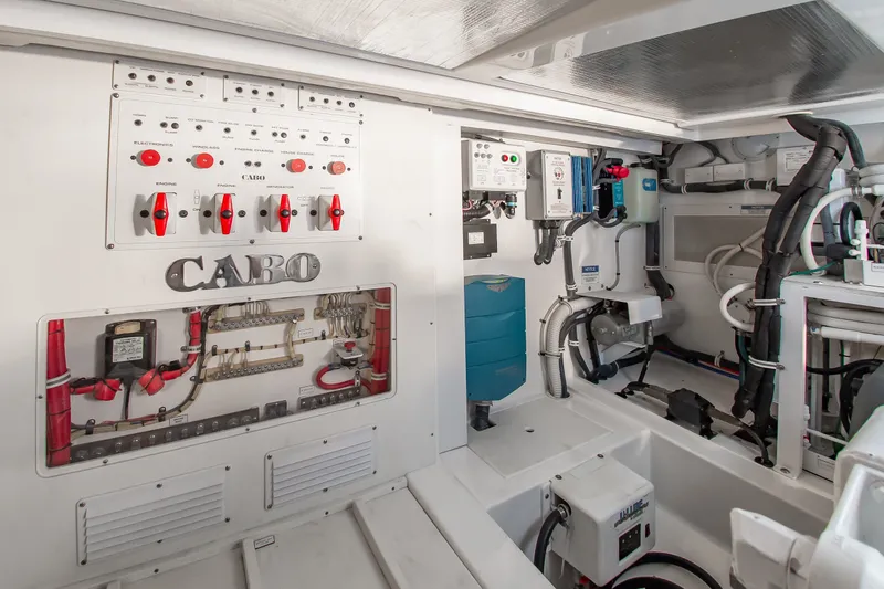 Slide: The Image of Engine room of 2013 Cabo 40 Hardtop Express, showcasing control panels and wiring. - 35