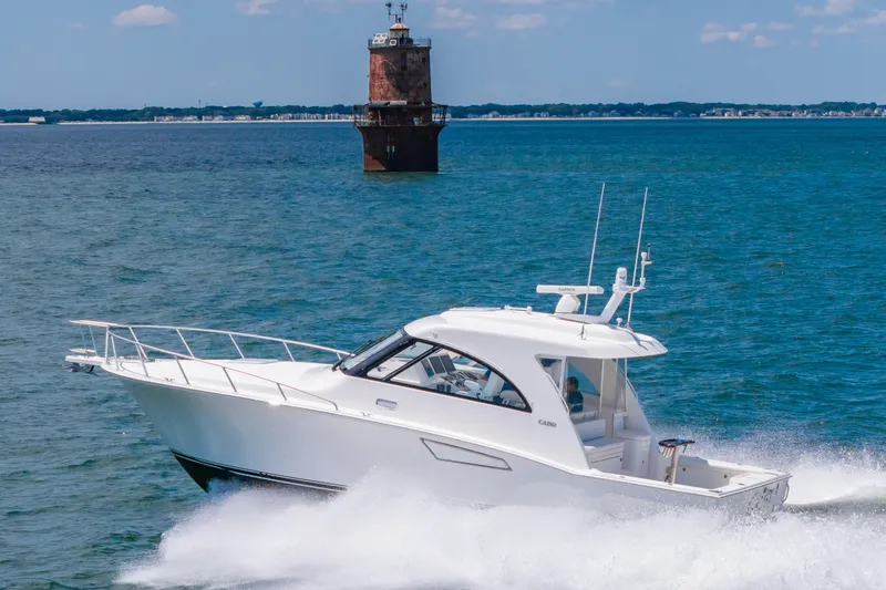 Slide: The Image of 2013 Cabo 40 Hardtop Express cruising near a lighthouse on a sunny day. - 31