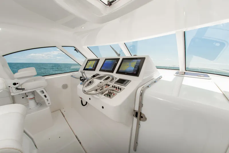 Slide: The Image of Helm of 2013 Cabo 40 Hardtop Express yacht with navigation screens and ocean view. - 14