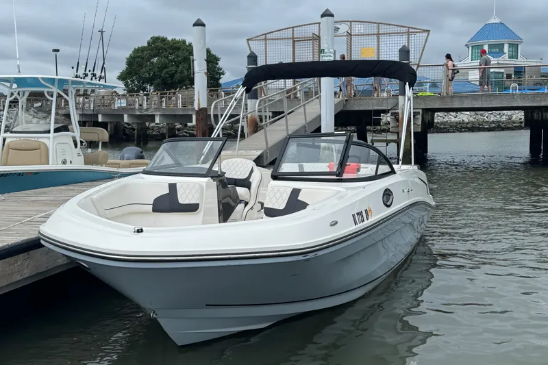 Slide: The Image of 2024 Bayliner VR6 Bowrider OB docked at marina, featuring sleek design and spacious seating. - 2