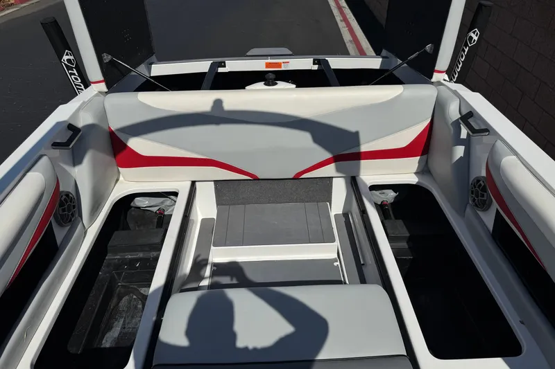 Slide: The Image of 2022 Axis T23 boat interior with red and gray seating, open storage compartments. - 17