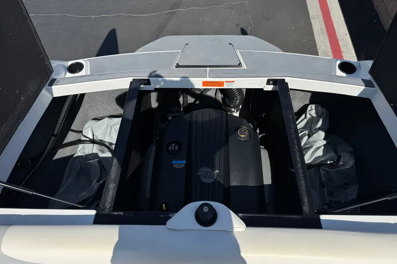 Slide: The Image of Engine compartment of a 2022 Axis T23 boat, showcasing the motor and storage area. - 18