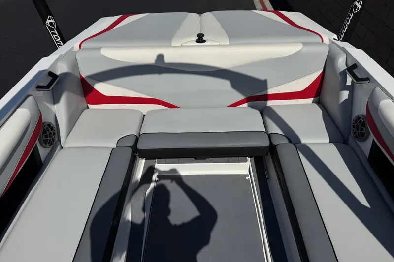 Slide: The Image of 2022 Axis T23 boat interior with gray and red seating, shadow visible. - 16