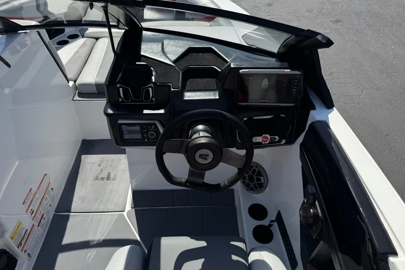 Slide: The Image of 2022 Axis T23 boat cockpit with steering wheel, dashboard, and seating area. - 28