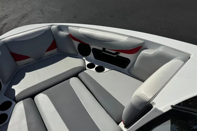 Slide: The Image of 2022 Axis T23 boat interior with gray and red seating, cup holders, and speaker. - 13