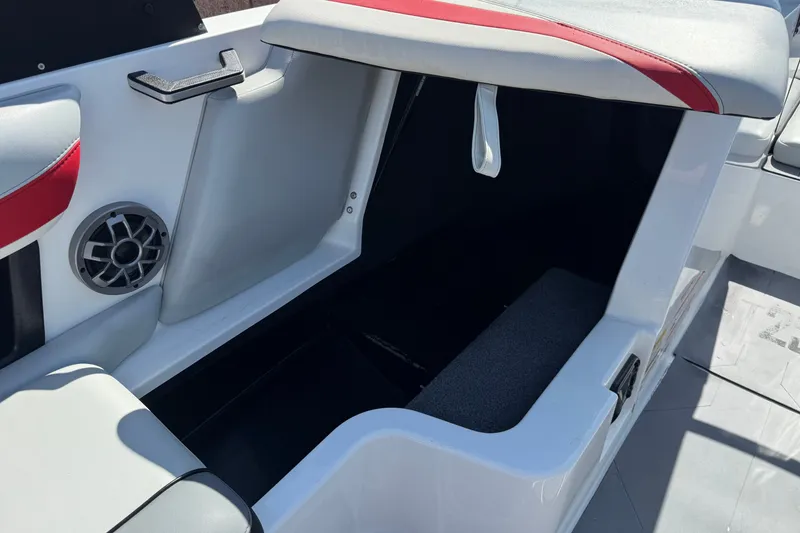 Slide: The Image of 2022 Axis T23 boat interior storage compartment with speaker and red-accented seating. - 24