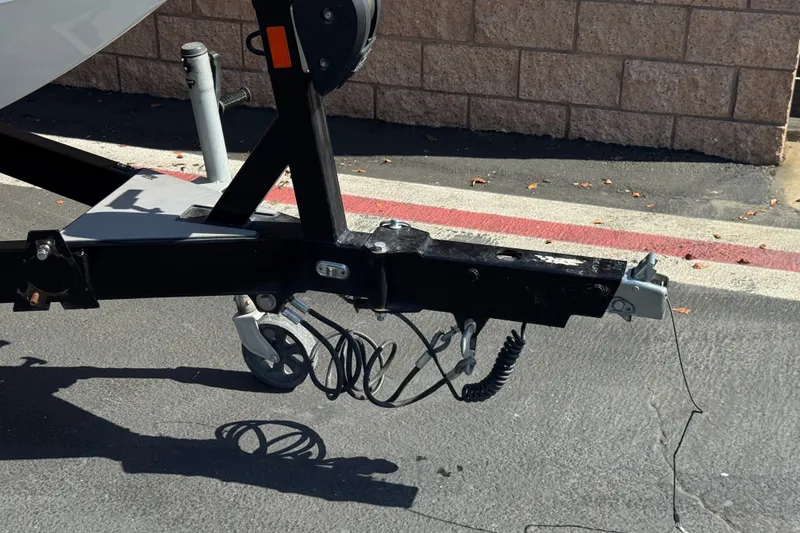 Slide: The Image of Trailer hitch of a 2022 Axis T23 boat on pavement near a brick wall. - 35