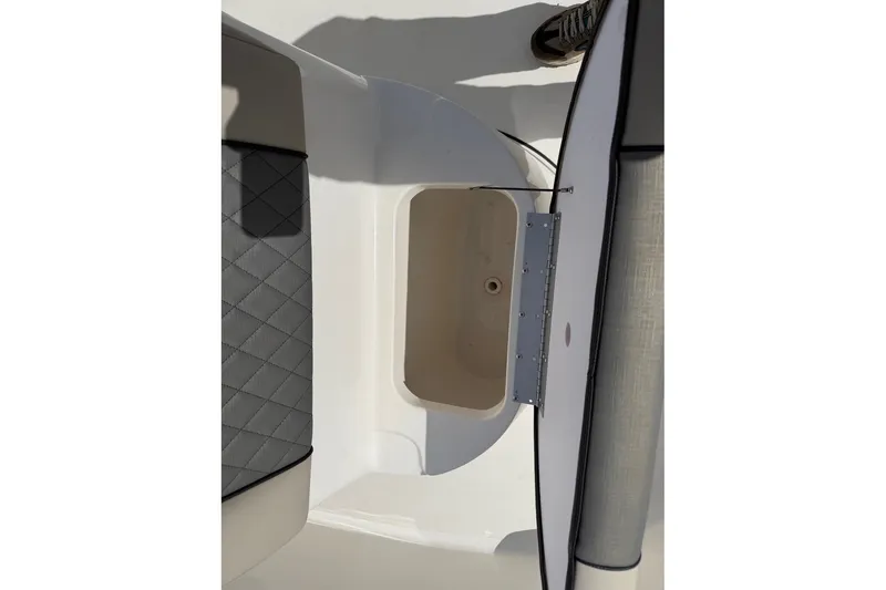 Slide: The Image of Open storage compartment on 2026 Key West 189 FS boat, featuring quilted seating. - 11