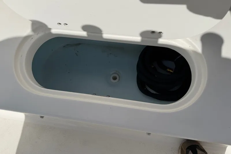 Slide: The Image of Storage compartment of 2026 Key West 189 FS boat, featuring a coiled hose. - 20