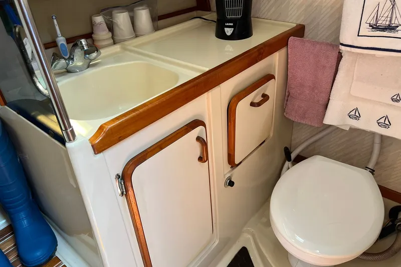 Slide: The Image of 1990 Hunter Legend 35.5 yacht bathroom with sink, toilet, and nautical-themed decor. - 32