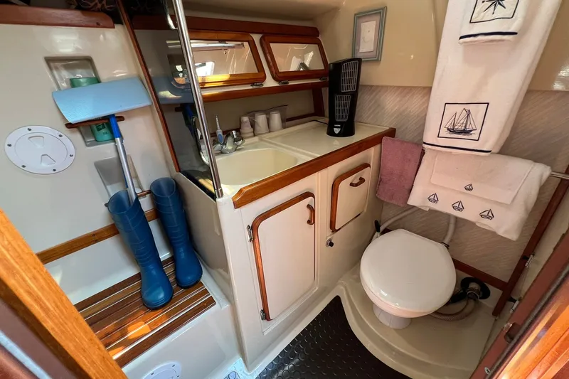 Slide: The Image of 1990 Hunter Legend 35.5 yacht bathroom with sink, toilet, and nautical-themed towels. - 30