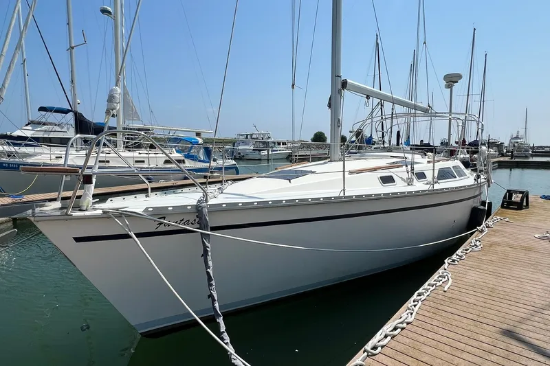 The Image of 1990 Hunter Legend 35.5 sailboat docked at marina under clear blue sky. - 0