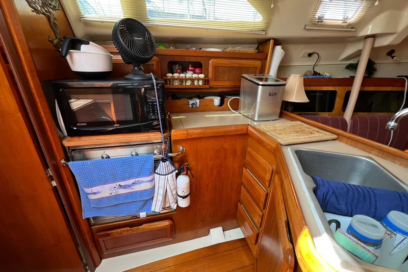 Slide: The Image of Cozy kitchen area in a 1990 Hunter Legend 35.5 sailboat with wooden cabinetry. - 17