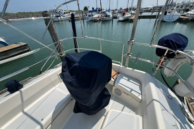 Slide: The Image of Hunter Legend 35.5 sailboat cockpit, 1990 model, docked in a marina with covered equipment. - 8