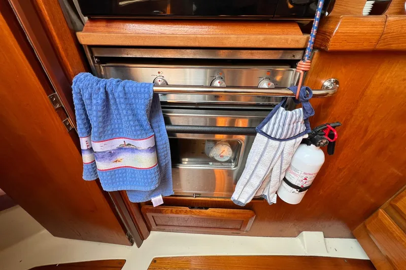 Slide: The Image of 1990 Hunter Legend 35.5 yacht kitchen with oven, towels, and fire extinguisher. - 18