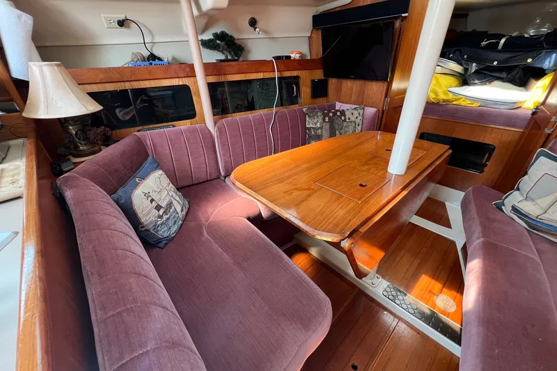 Slide: The Image of Interior of a 1990 Hunter Legend 35.5 sailboat with cozy seating and wooden table. - 21