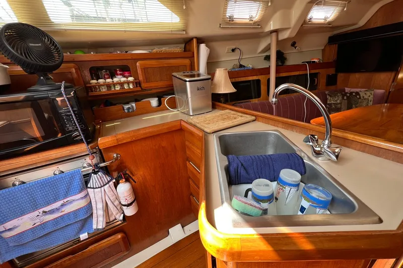 Slide: The Image of Interior of a 1990 Hunter Legend 35.5 with kitchen, sink, and wooden cabinets. - 16