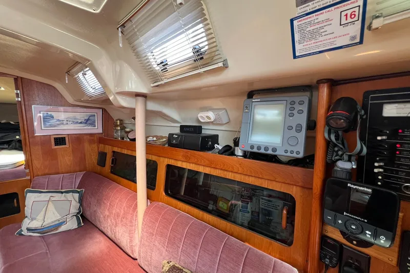 Slide: The Image of Interior of a 1990 Hunter Legend 35.5 sailboat with navigation equipment and cozy seating. - 22