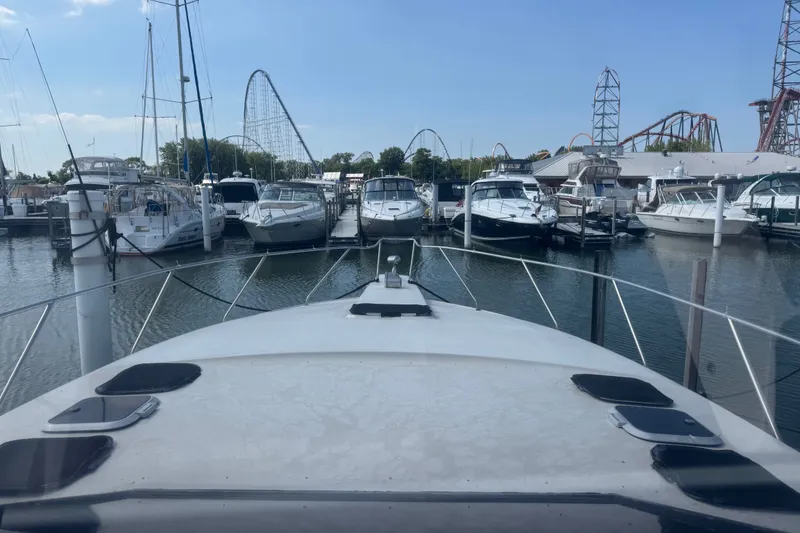 Slide: The Image of 1990 Silverton 34 Express yacht docked in marina with amusement park rides in background. - 17