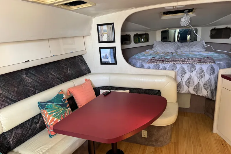 Slide: The Image of Interior of a 1990 Silverton 34 Express yacht with cozy seating and bed area. - 20