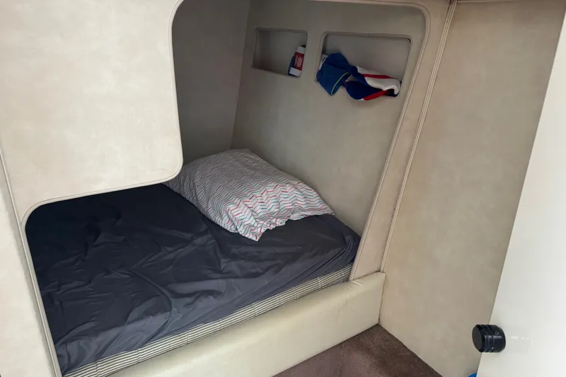 Slide: The Image of Cozy cabin interior of 1990 Silverton 34 Express with bed and storage shelves. - 24