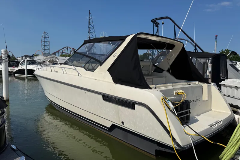 The Image of 1990 Silverton 34 Express boat docked at marina with amusement park in background. - 1